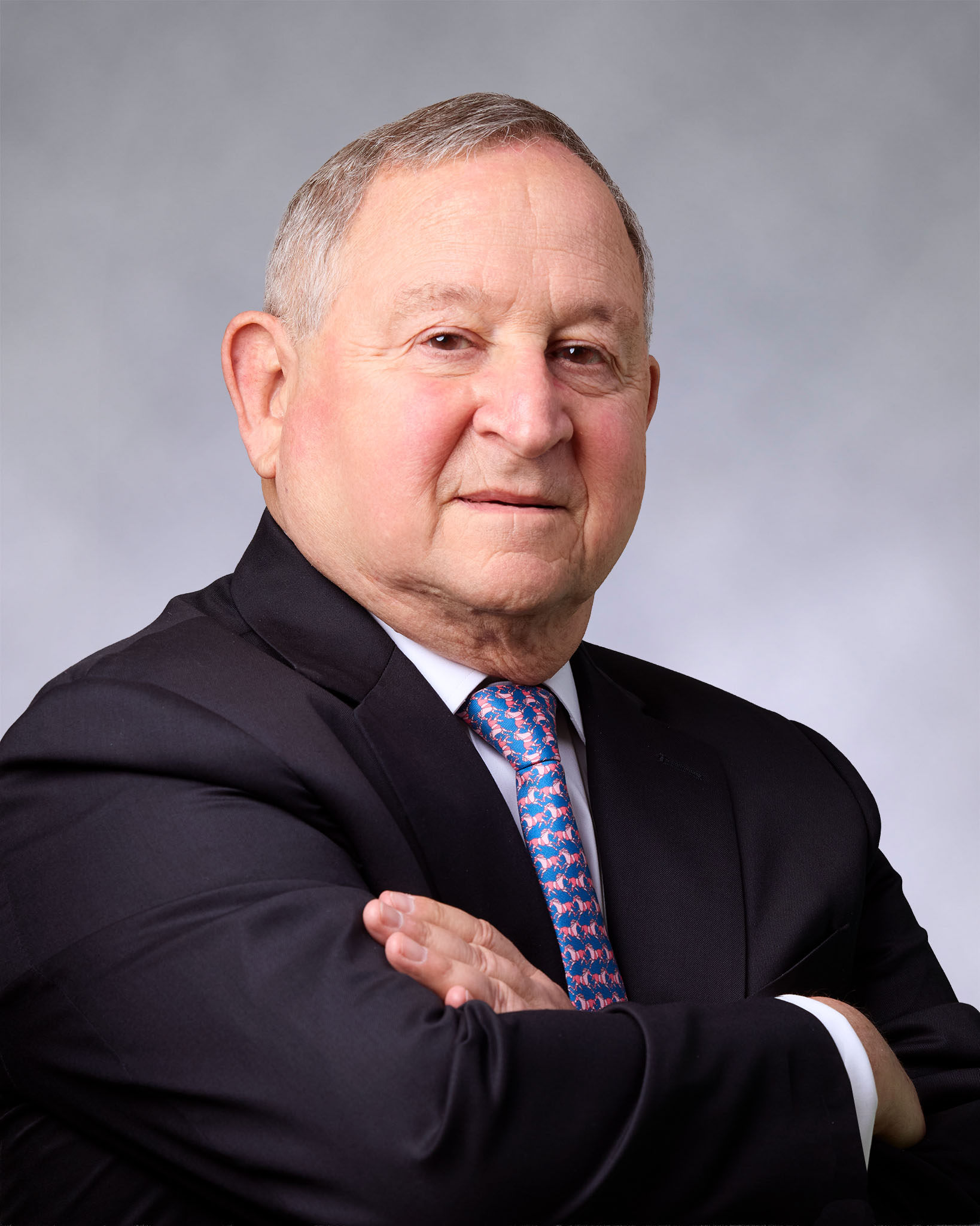 Portrait of Bernard Dane Stein, tax attorney in a suit with arms crossed